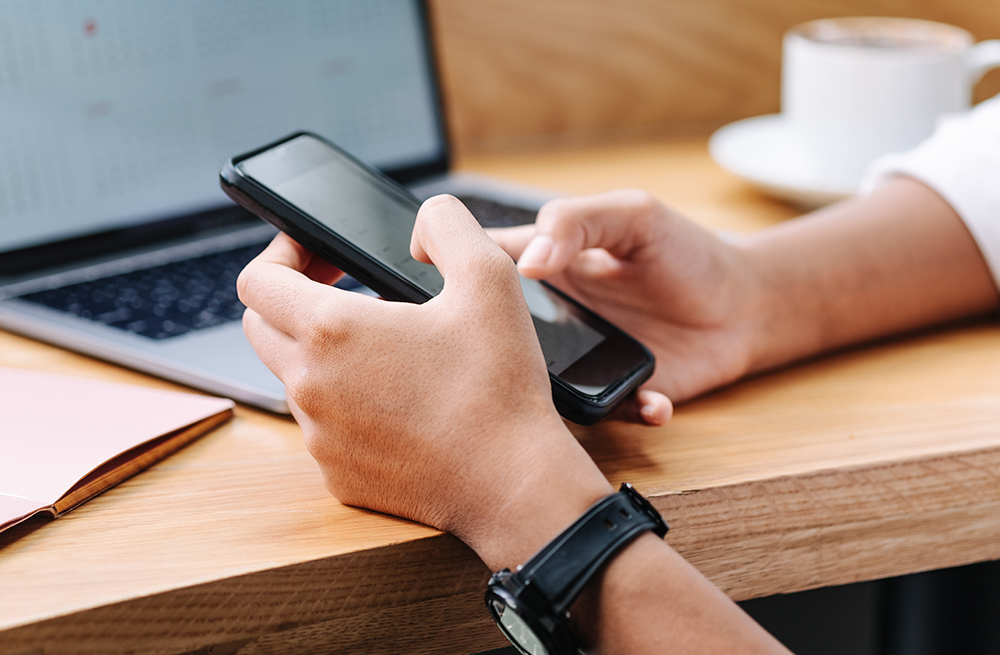 Mann ser på ofte stilte spørsmål til Eversense diabetes på en telefon.